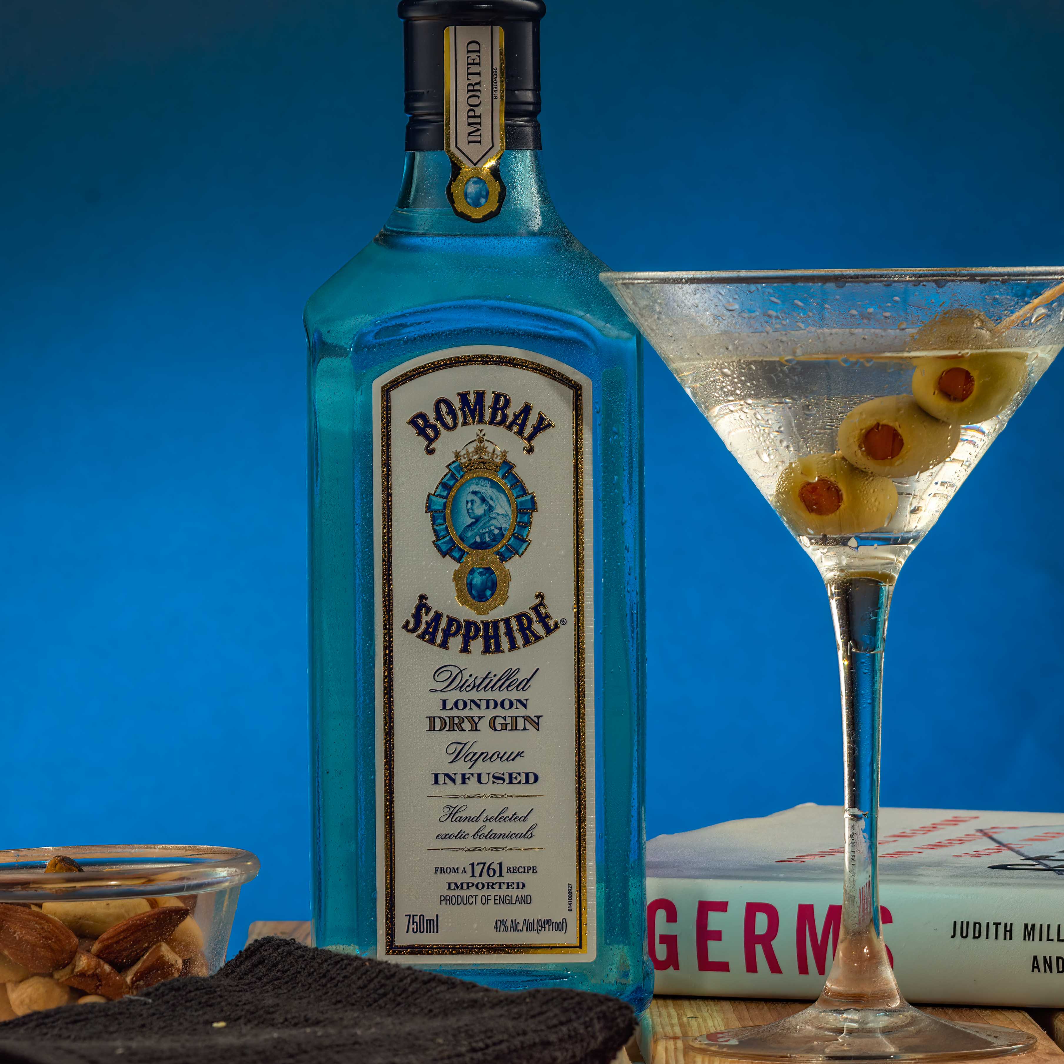 Gin martini composite - shot in studio bombay gin martini with bottle and olives and book composite shot in studio